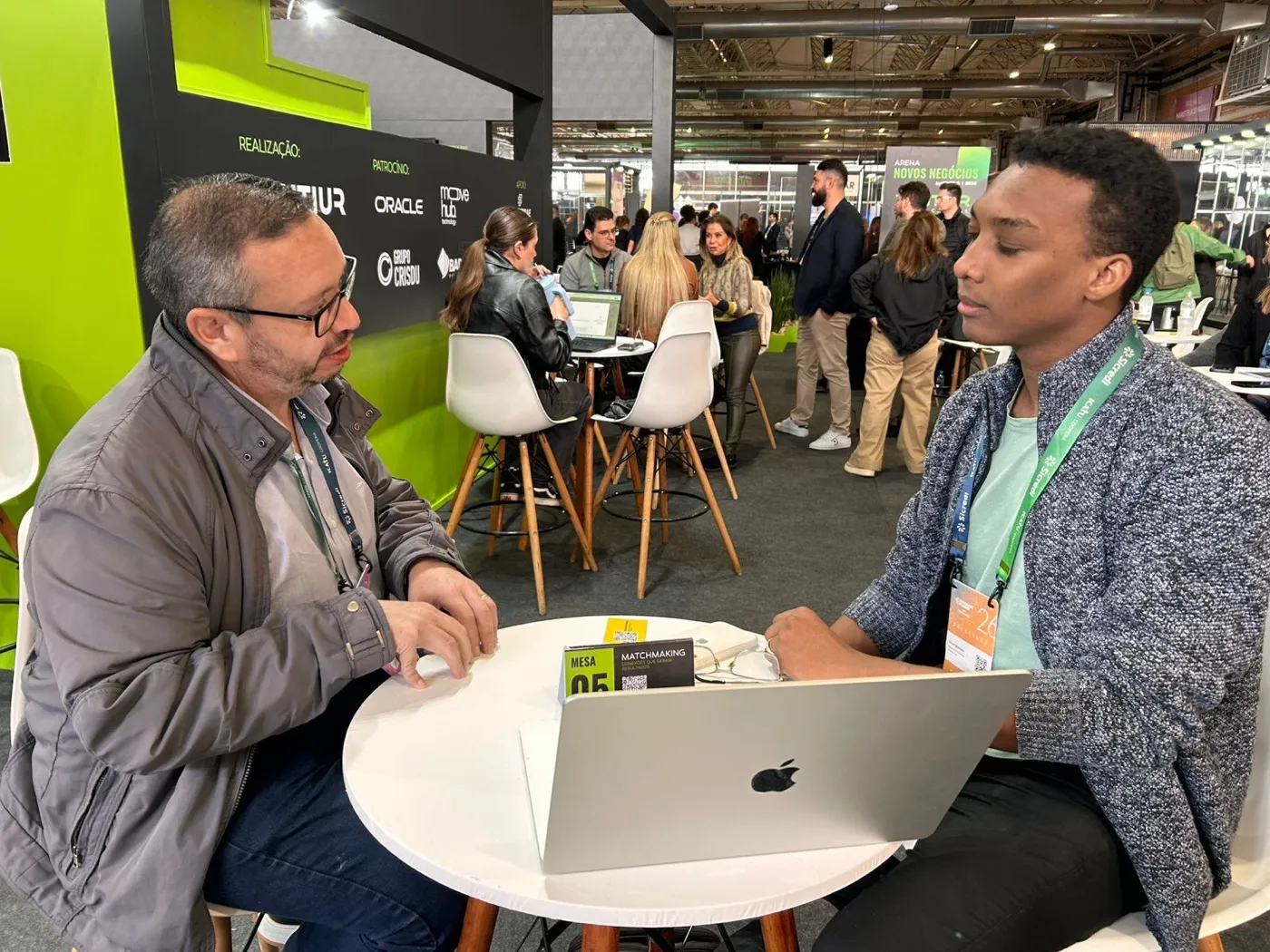 Vanei atendendo um visitante com o notebook aberto na banca do Gramado Summit